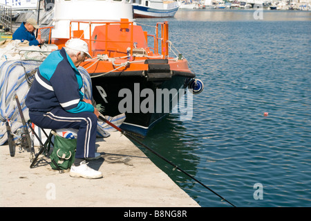 Spagnolo anziano uomo Angler Angling pesca sul Quayside Torrevieja Spagna Foto Stock