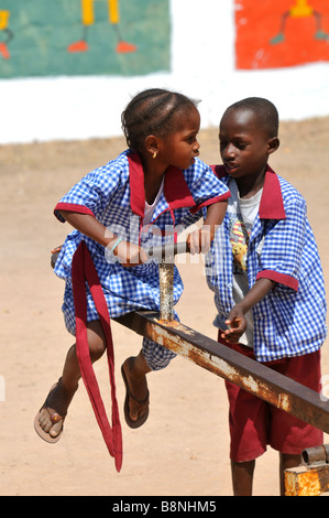 Scuola gambiana gli alunni a giocare nel parco giochi della scuola, Gambia, Africa occidentale Foto Stock