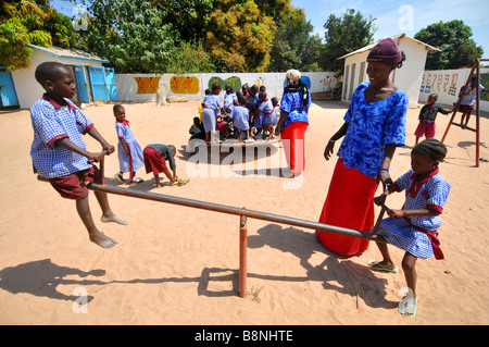 Scuola gambiana gli alunni a giocare nel parco giochi della scuola, Gambia, Africa occidentale Foto Stock