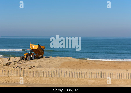 Il trattore si muove la sabbia sulla spiaggia di Anglet FRANCIA Foto Stock