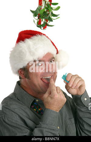 Un uomo con un respiro rinfrescante preparando per un bacio sotto il vischio Foto Stock