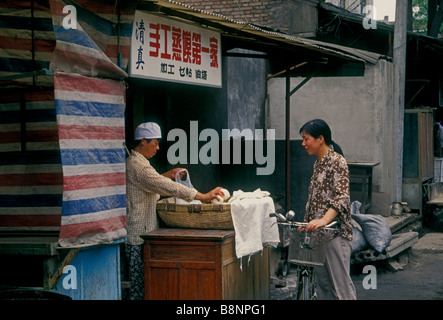 Donna cinese, donna musulmana, fornitore di prodotti alimentari, mercato all'aperto, il mercato, il Quartiere Musulmano, Xian, Provincia di Shaanxi, Cina e Asia Foto Stock