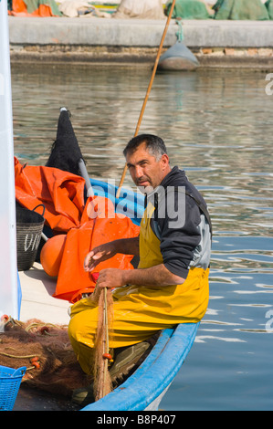 Pescatore spagnolo uomo rammendo che ripara le sue reti da pesca a Santa Pola Spagna Foto Stock