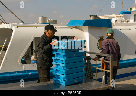 Impilatura di pescatori i suoi vassoi di pesce fresco delle catture a bordo di un carro pronto per essere portato al Mercato di Santa Pola Spagna Foto Stock