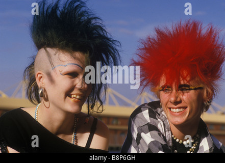 Punk teen giovane degli anni ottanta ragazzo con i capelli rossi e giallo e occhio nero ragazza trucco con metà testa rasata circa 1985 Londra UK HOMER SYKES Foto Stock