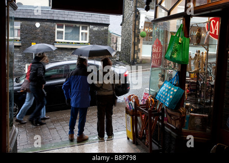 Turisti sotto la pioggia in Bowness on Windermere Foto Stock