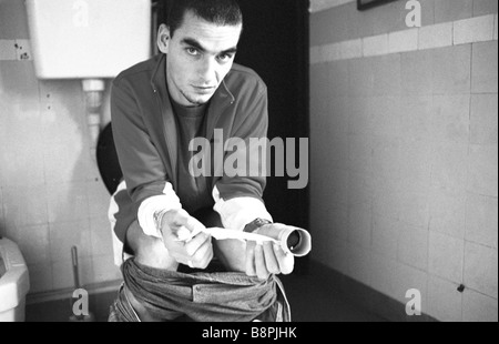 Uomo con wc, tenendo bobina vuota di tessuto Foto Stock