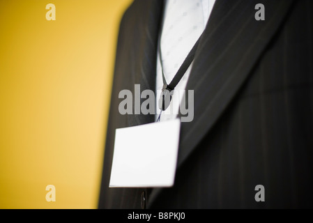 Uomo in abito indossando identificativi vuoto attorno al collo, ritagliato Foto Stock