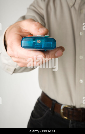 Mano utilizzando un telecomando del televisore Foto Stock