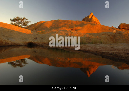 Il mirroring Spitzkoppe sulla superficie dell'acqua nella luce della sera, Namibia Foto Stock