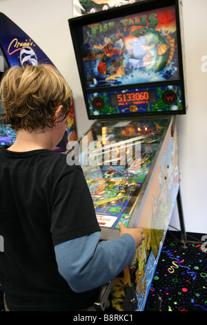 Bambino giocare a flipper gioco arcade Foto Stock