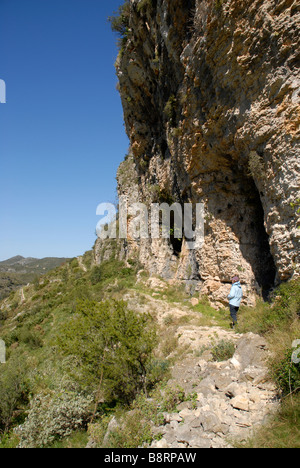 Donna escursionista esplorare grotte off mozarabo trail, Vall de Laguart, Benimaurell, Provincia di Alicante, Comunidad Valenciana, Spagna Foto Stock