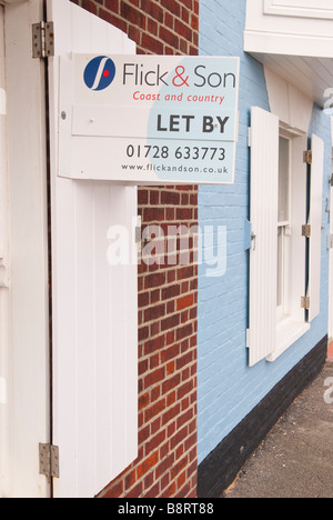 Una per la vendita segno da Flick & figlio costa e paese l'agente immobiliare su una casa in Aldeburgh,Suffolk, Regno Unito Foto Stock