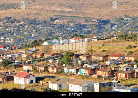 Grandi case in mattoni, con un materiale di riempimento o infill' di 'baracche di stagno', prendere il sole del mattino sul bordo occidentale della township di Grahamstown Foto Stock