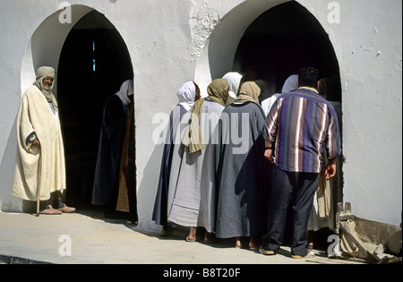Gli uomini in piedi di fronte a una casa, Tunisia, Jerid, Oase Douz Foto Stock