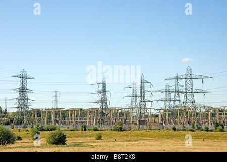 Elettricità tralicci e sottostazione da un campo di Sun Foto Stock