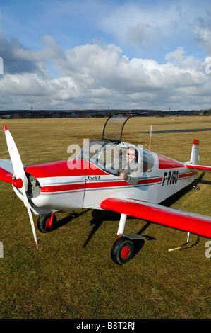 Un vecchio aereo francese Uno "Jodel" D-113 (costruire durante gli anni cinquanta) pronto alla partenza con il suo giovane pilota Foto Stock