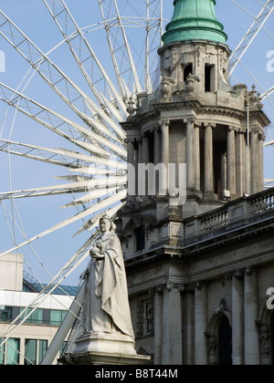 Belfast town hall e l'occhio la ruota con la statua della regina Victoria in primo piano Foto Stock