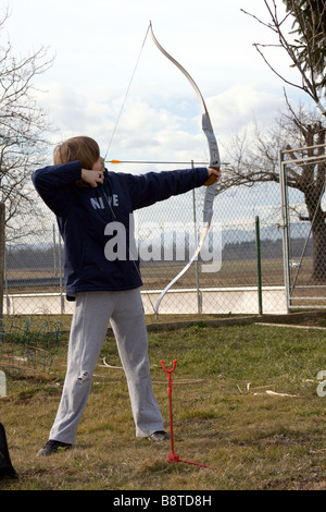 Ragazzo adolescente archer la professione nel cortile. Foto Stock