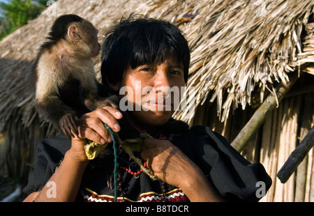 Una donna Kuna gioca con il suo animale domestico cariblanca faccia bianca scimmia cappuccino in un villaggio a Panama la regione di Darien Foto Stock