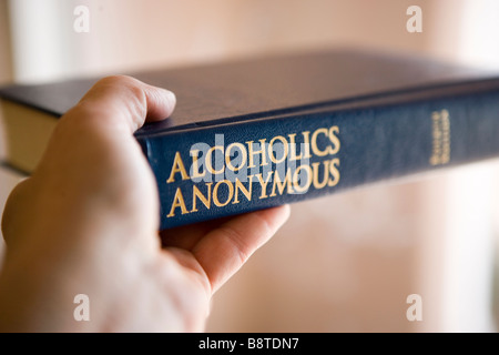 Una persona che tiene "Il grande libro' di Alcolisti Anonimi Foto Stock