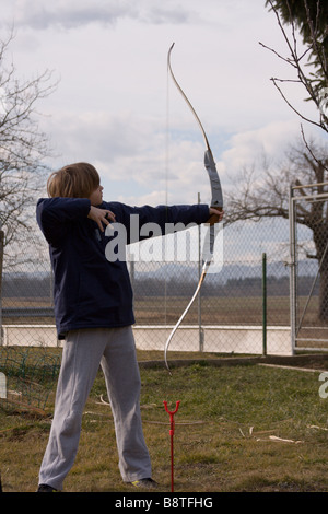 Ragazzo adolescente archer la professione nel cortile. Foto Stock