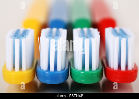 Fila di quattro diversi spazzolini da denti colorati Foto Stock