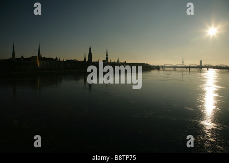Skyline di Riga, Lettonia, accanto al fiume congelato Daugava durante l'inverno. Foto Stock