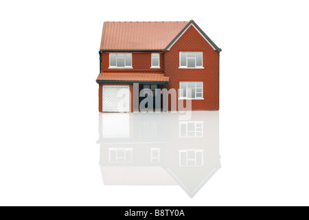 Un modello di casa isolata su uno sfondo bianco con la riflessione Foto Stock
