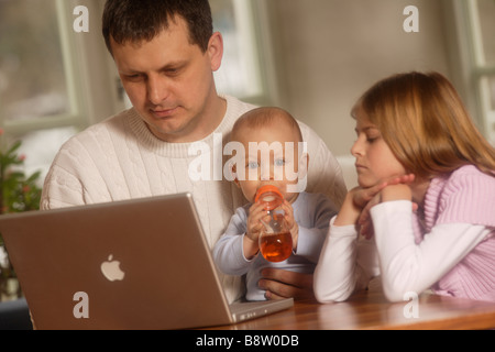 Childerns e padre lavorare con il computer portatile Foto Stock