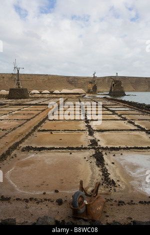 Rusty carriola e mulini a vento in un saltmine abbandonati in Lanzarote, Spagna. Foto Stock