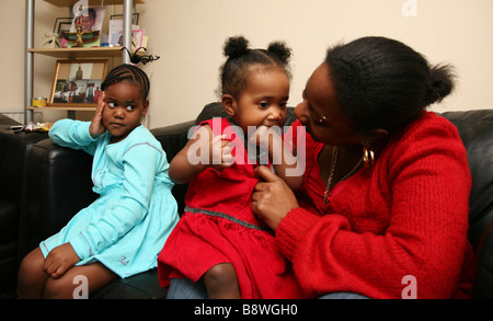 Single parent family, madre giocando con la figlia più giovane mentre la primogenita si sente lasciato fuori Foto Stock