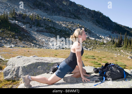 Giovane donna in montagna a praticare lo yoga Foto Stock