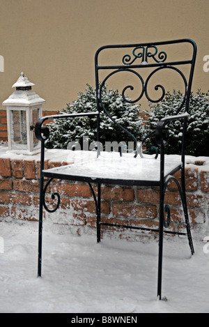 Rustico in ferro battuto giardino sedile e una lampada a luce coperchio lanterna con neve invernale Foto Stock