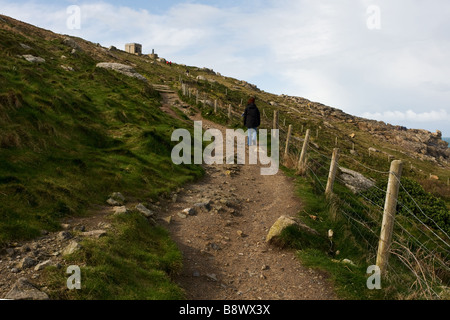 Un viandante sul sentiero fino alla vecchia guardia costiera Stazione di vedetta a Sennen in Cornovaglia. Foto Stock