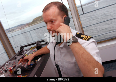 Un ufficiale della Flotta Reale ausiliari di utilizza un telefono radio sul ponte dell'onda RFA righello Foto Stock