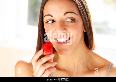 Donna di mangiare una fragola Foto Stock