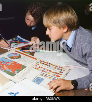 Una scuola secondaria di un ragazzo e una ragazza a studiare un libro di geografia con mappa e bandiere di Europa in uno degli anni novanta la scuola secondaria aula Wales UK KATHY DEWITT Foto Stock