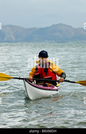 Un solitario kayaker di mare al largo della costa di Anglesey, Galles, UK. Foto Stock