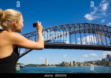 Una donna fotografa il Harbour Bridge su una crociera del porto. Sydney, Nuovo Galles del Sud, Australia Foto Stock