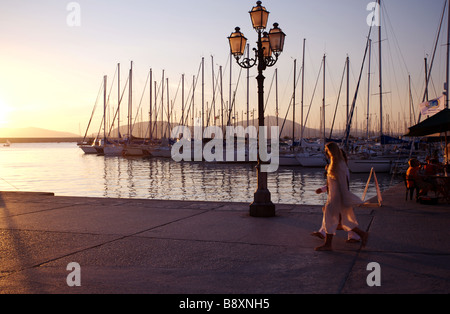 Due persone a piedi lungo la passeggiata durante il tramonto in alghero vestito di bianco Foto Stock