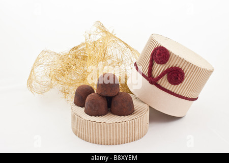 Tartufi fatti a mano su un coperchio di cartone regalo sfondo bianco Foto Stock