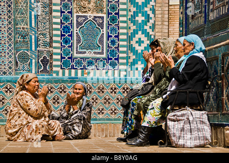 Il gruppo di donne musulmane in preghiera nell'Shahr-i-Zindah mausoleo, Samarcand, Uzbekistan Foto Stock
