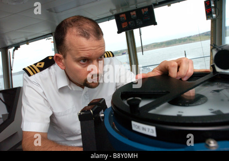 Un ufficiale della Flotta Reale utilizza ausiliario di una bussola di avvistamento sul ponte dell'onda RFA righello Foto Stock