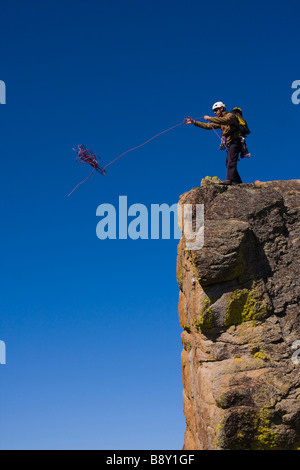 Alpinista di gettare una fune di arrampicata da un dirupo, Lake Tahoe, Nevada, STATI UNITI D'AMERICA Foto Stock