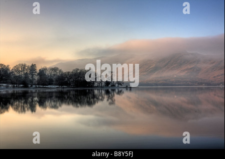 Presi la mattina presto i primi raggi di sole catture il fells sul lato lontano della Derwentwater. Foto Stock
