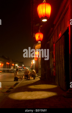 Scena notturna con le persone al di fuori seduta in una delle strade di Pingyao, Provincia di Shaanxi, Cina. Foto Stock