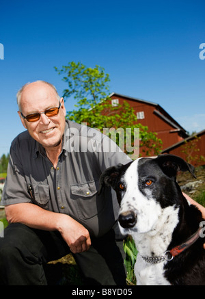 Un uomo che gioca con un cane in Svezia. Foto Stock