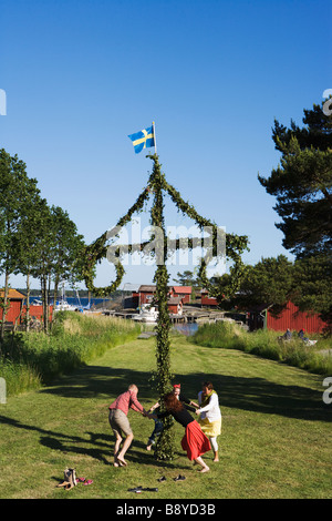La gente ballare tutto il maypole per la festa di mezza estate in Svezia. Foto Stock