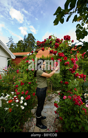 Una donna giapponese nel suo giardino svedese in Svezia. Foto Stock